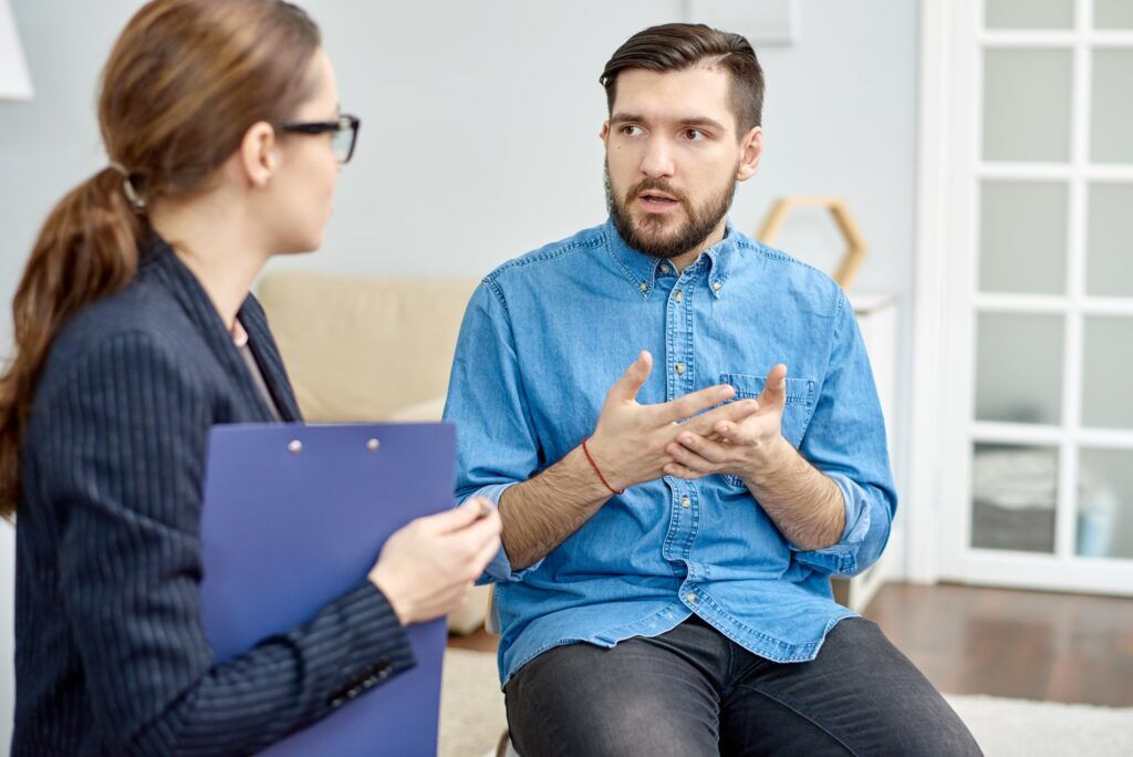 a man with symptoms of schizoaffective disorder speaking with a mental health professional about his psychotic symptoms, mood symptoms, and depressive symptoms so that they can treat his mental illness