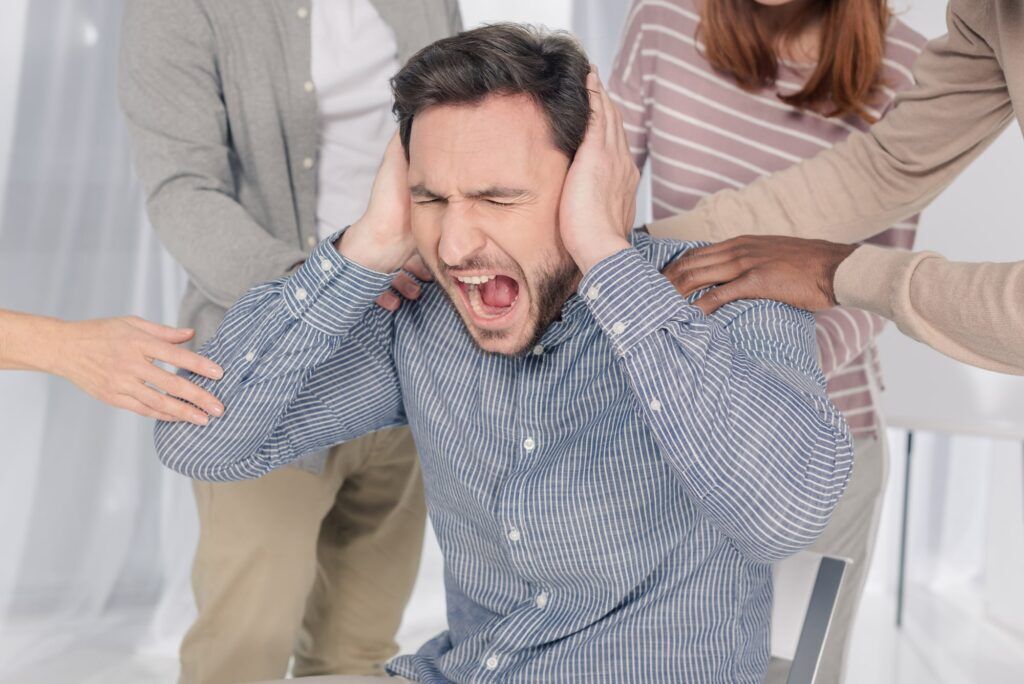 A man with schizoaffective disorder experiencing a mental health crisis and people surrounding him in support